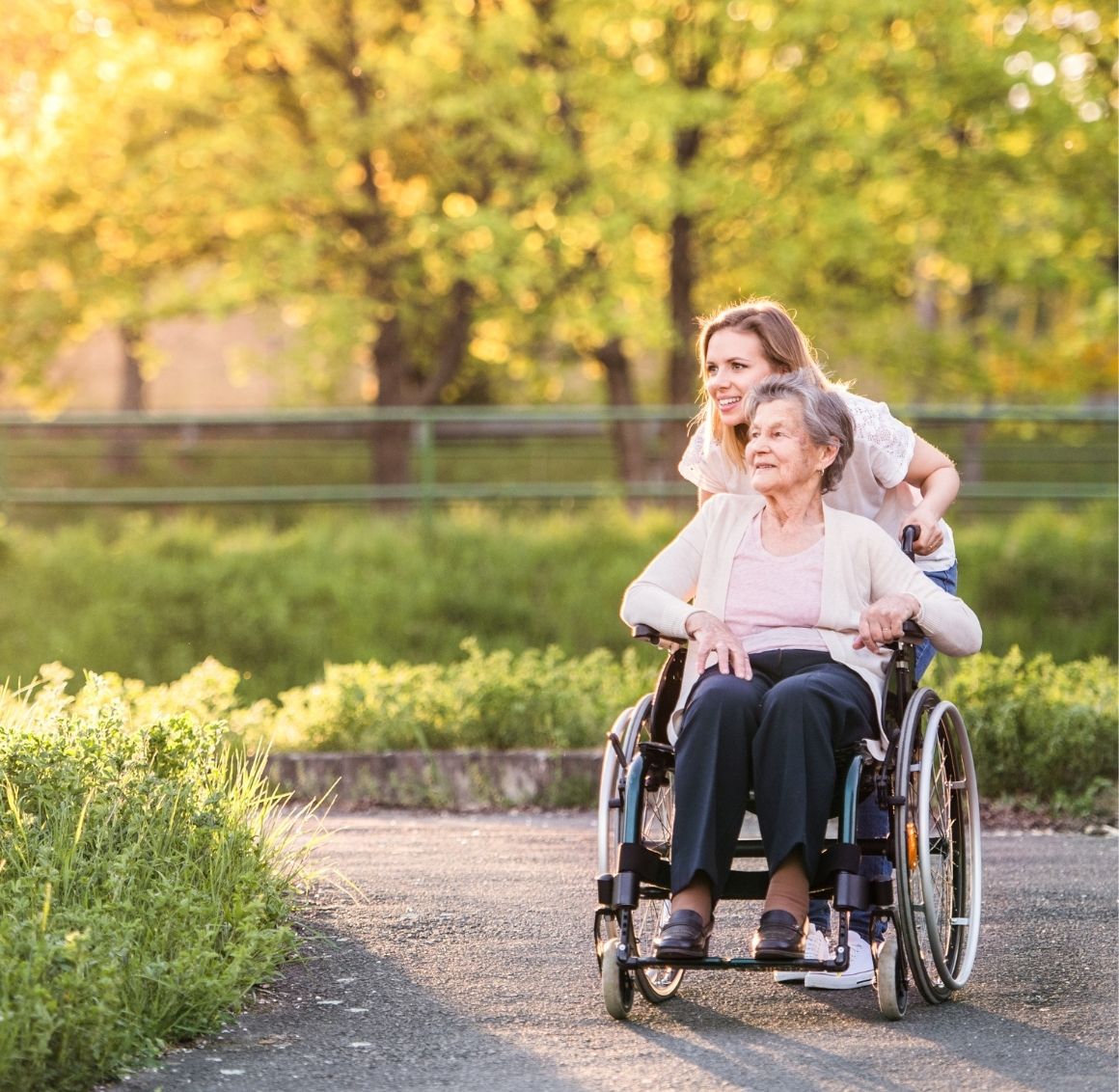 Caregiver and elderly client smiling together during an in-home visit to discuss personalized care.