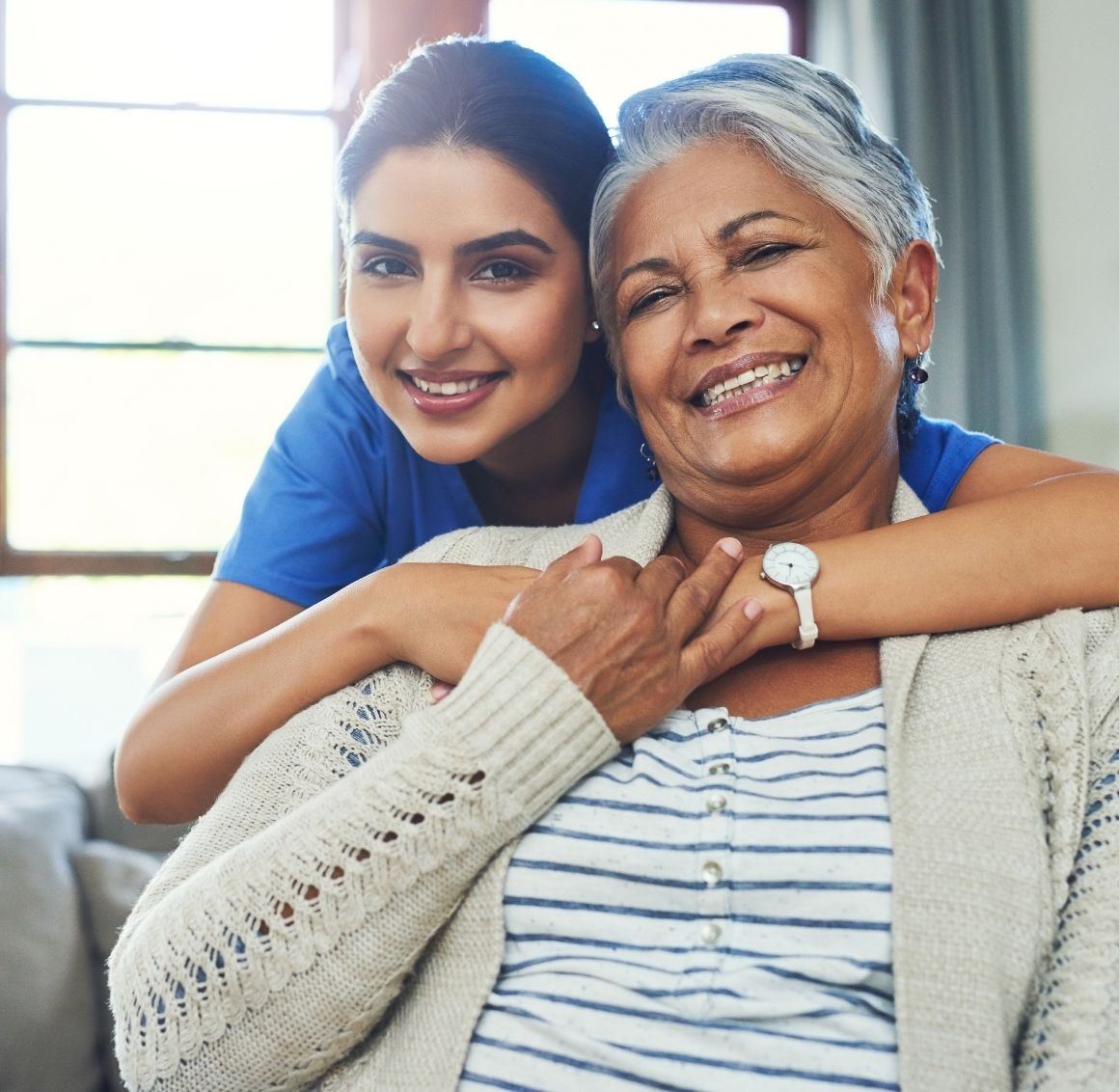 Comforting, compassionate care Caregiver giving a warm hug to an elderly woman to provide comfort and reassurance.
