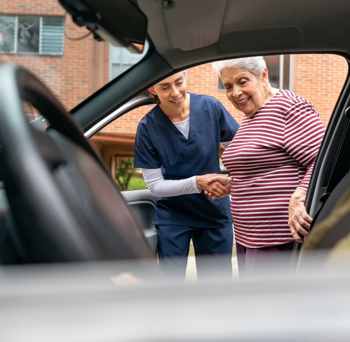 Transportation & appointment support Caregiver helping an elderly woman safely into a car for a doctor’s appointment.