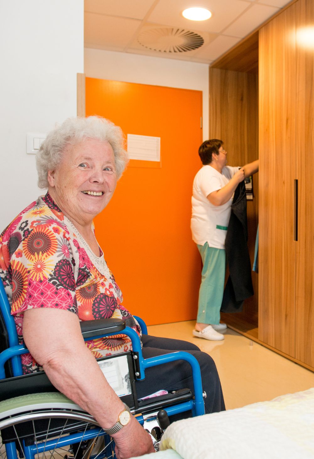 Housekeeping & home safety Caregiver vacuuming and tidying a living room to keep an elderly client's home clean and safe.