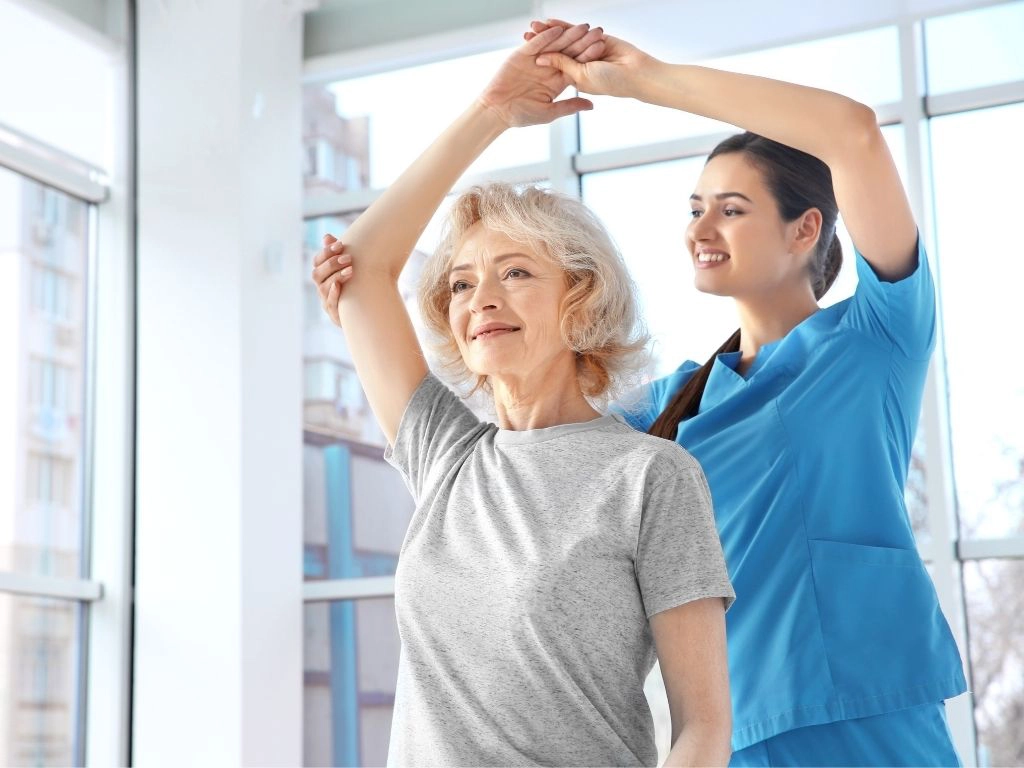 physical therapist assisting senior