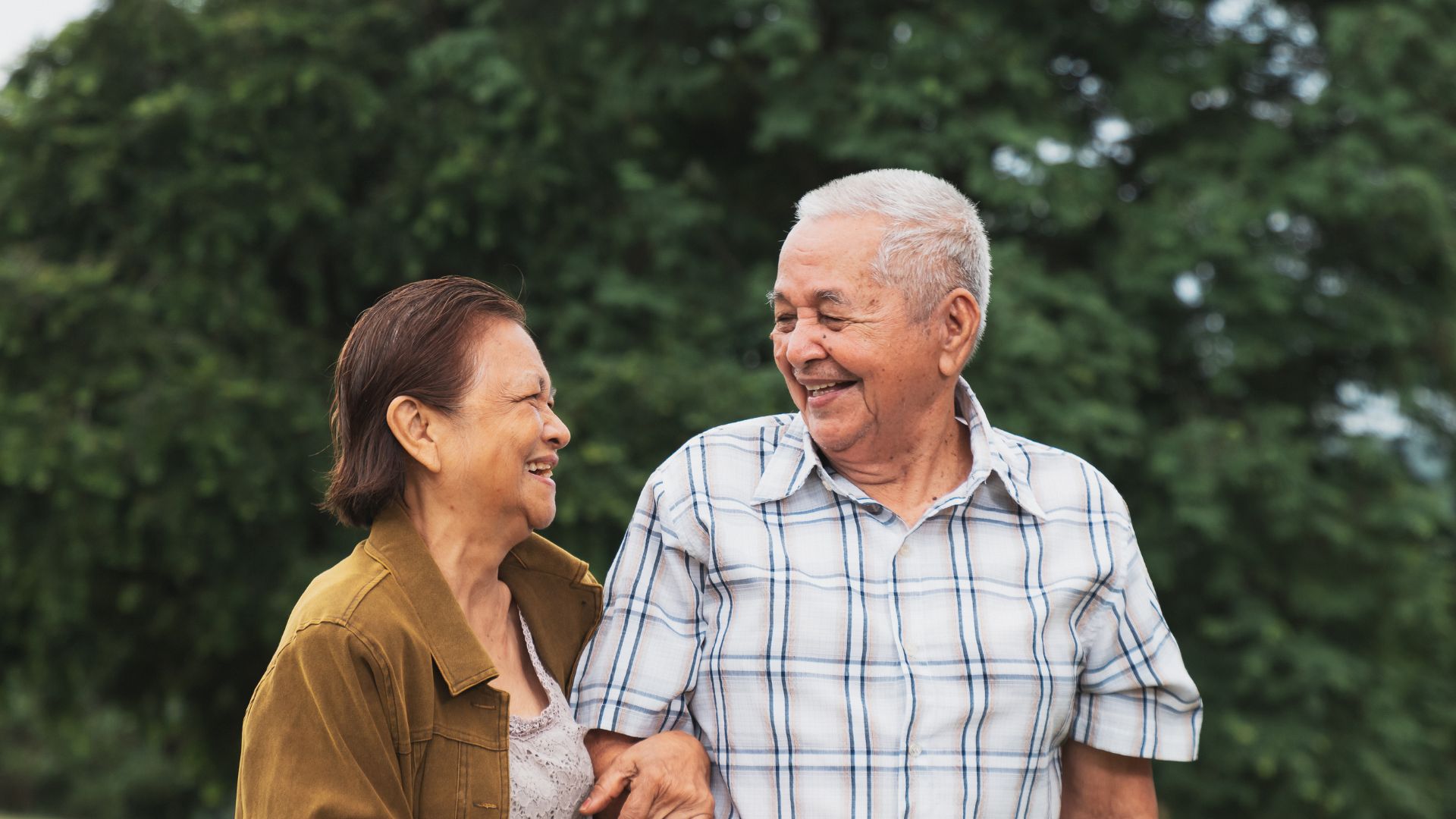 Smiling senior couple walking outdoors together, representing active senior living and home care in Eden Prairie.