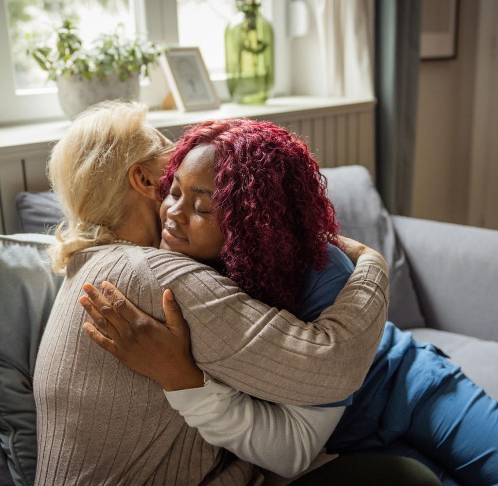 Caregiver hugging a senior woman at home, representing compassionate home care in Eden Prairie.