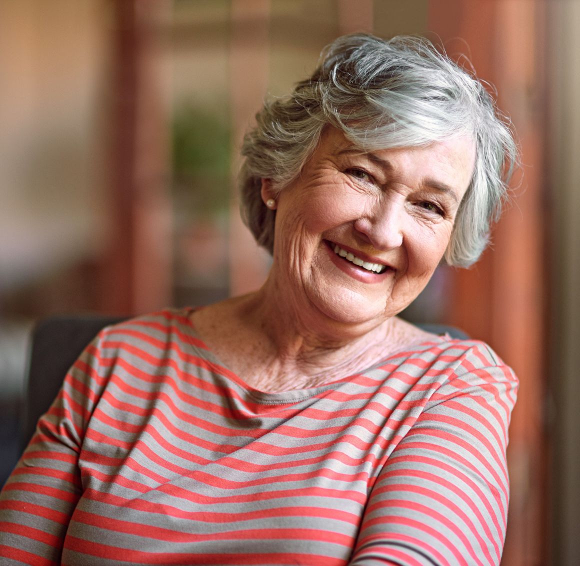 Smiling senior woman sitting comfortably at home receiving home care in Bloomington, MN